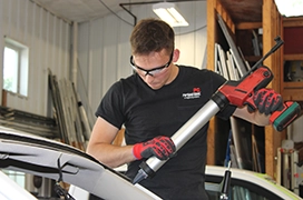 A Portland Glass technician working on a customer's rear car windshield.