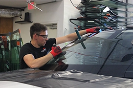 A Portland Glass technician working on a customer's car windshield.