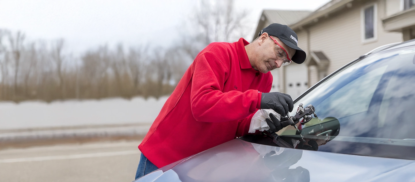 A Portland Glass technicians working on an auto windshield.