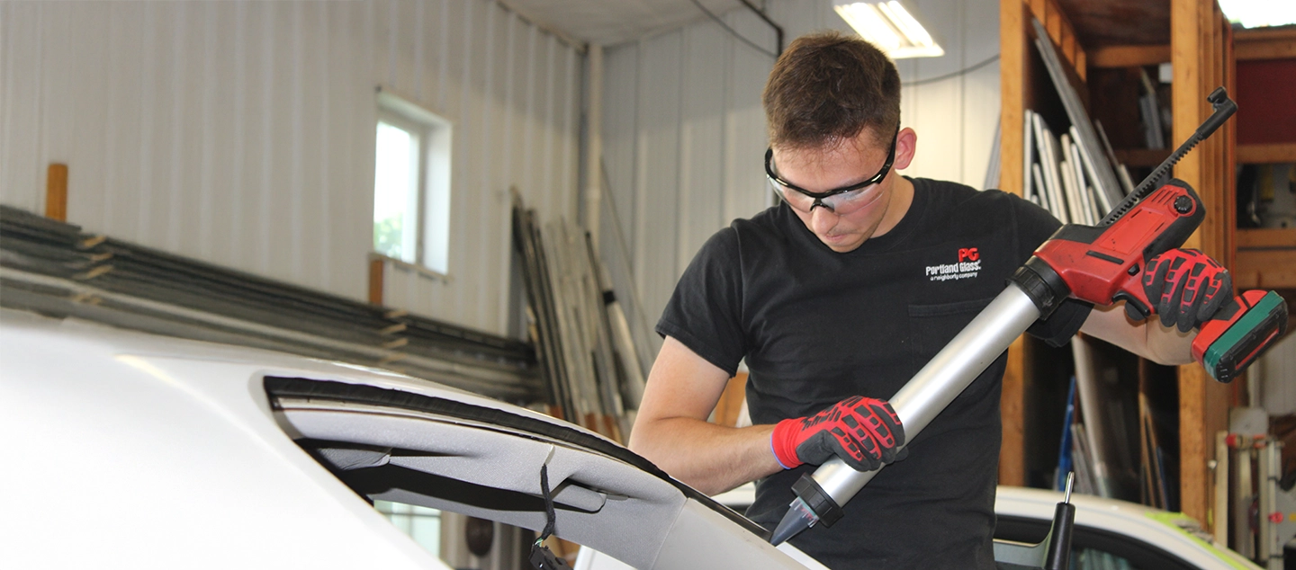 A Portland Glass technician working on the windshield of a customer's car.