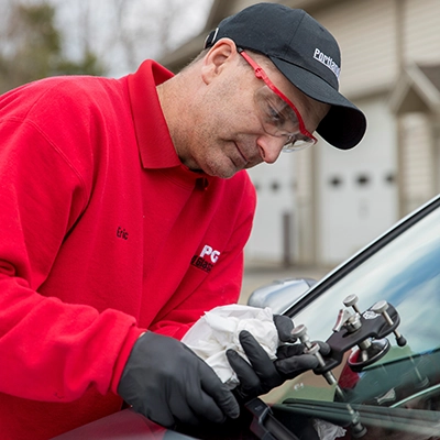 Portland Glass technician working on a windshield of a car.