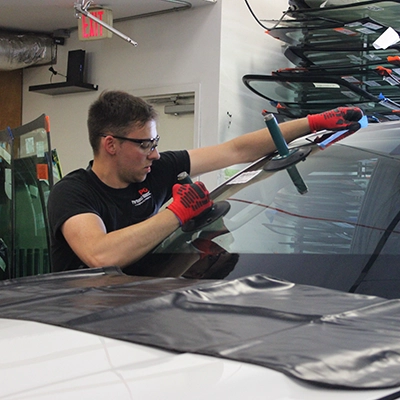 Portland Glass technician working on a windshield of a car.