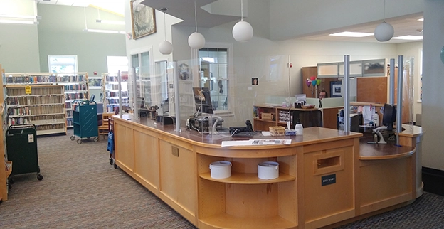 A library desk with sneeze guards surrounding it.
