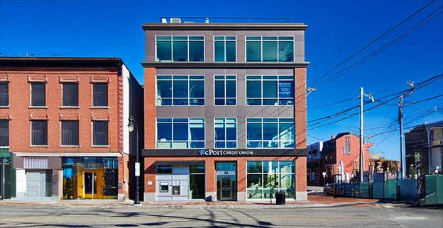 The front of a commercial building with glass doors and windows.