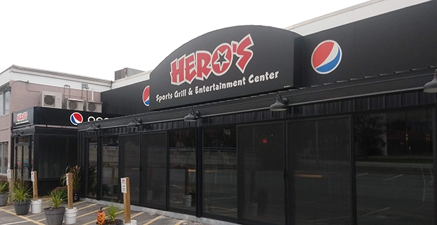A picture of a restaurant storefront with glass windows and doors.