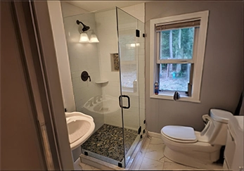 Compact Frameless Glass Shower with Black Hardware.