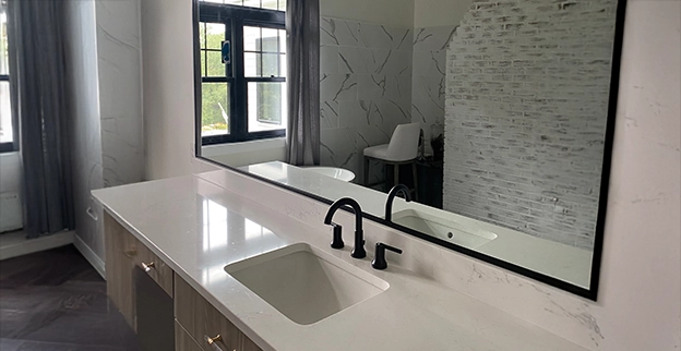 A picture of a custom mirror above a bathroom vanity.