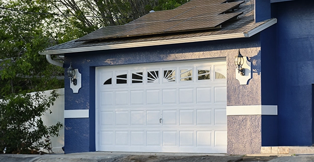 A picture of a white garage door with glass window panes.