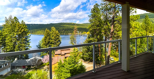 A picture of a glass railing on a balcony overlooking a lake.