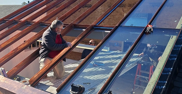 A picture of a Portland Glass technician installing an insulated glass roof.