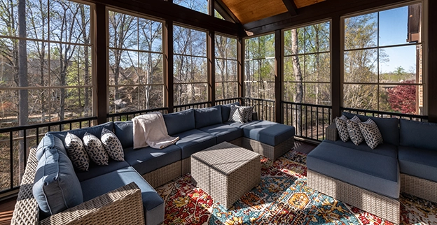 A patio sunroom naturally lit with floor to ceiling glass windows.