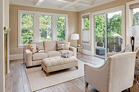A picture of a living room naturally lit by glass windows.