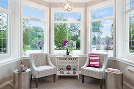 A sunroom lit by large glass windows.