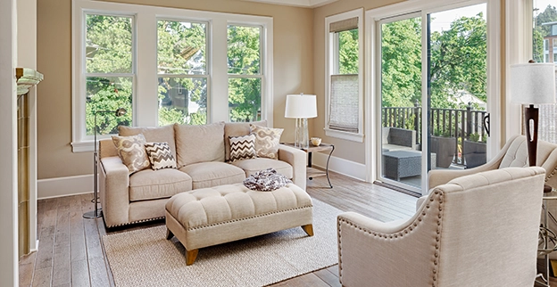 A picture of a living room surrounded by floor to ceiling glass windows.