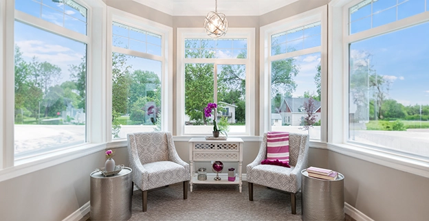 A picture of a sun room with large glass windows.
