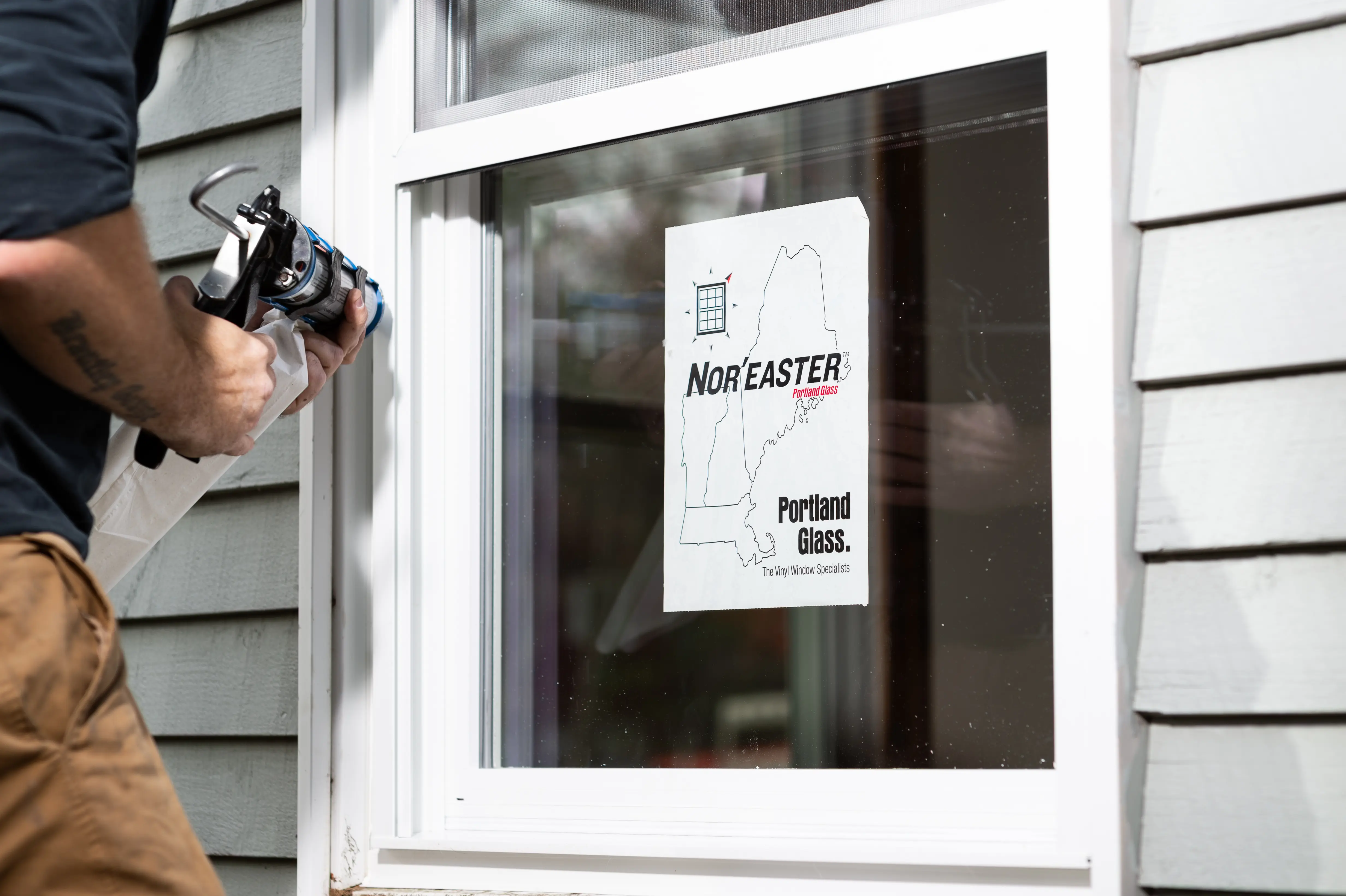 A picture of a Portland Glass window installation specialist installing a NOR’EASTER vinyl storm window.