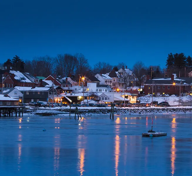 Night View Of The Snow Capped Homes On The Lake.