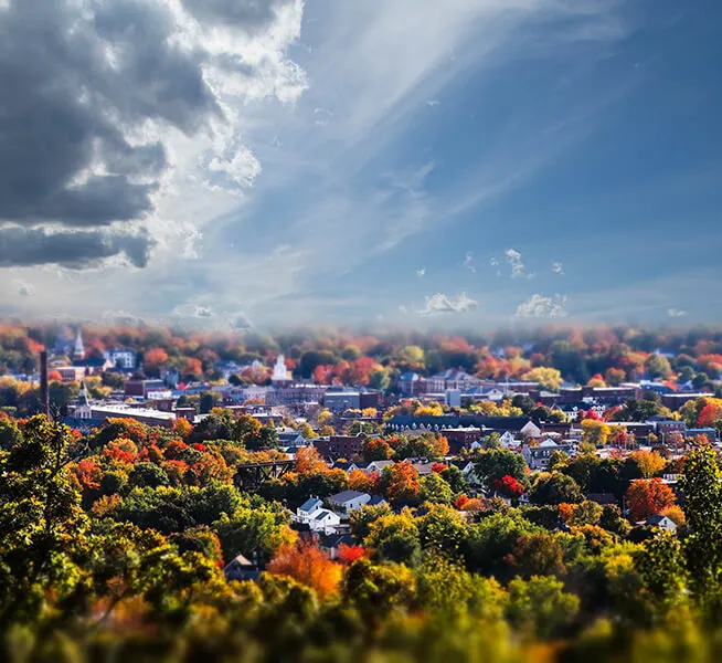 View of a town in the fall where trees are changing color.