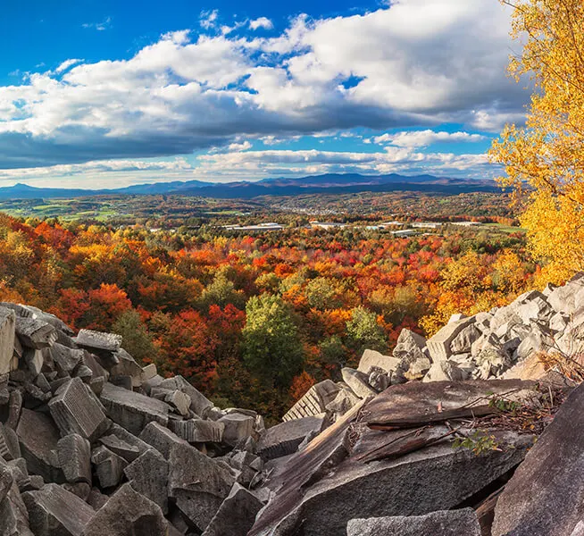 View of the autumn trees over a mountain of rocks.